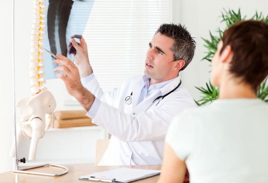O médico examina unha radiografía para diagnosticar a osteocondrose torácica